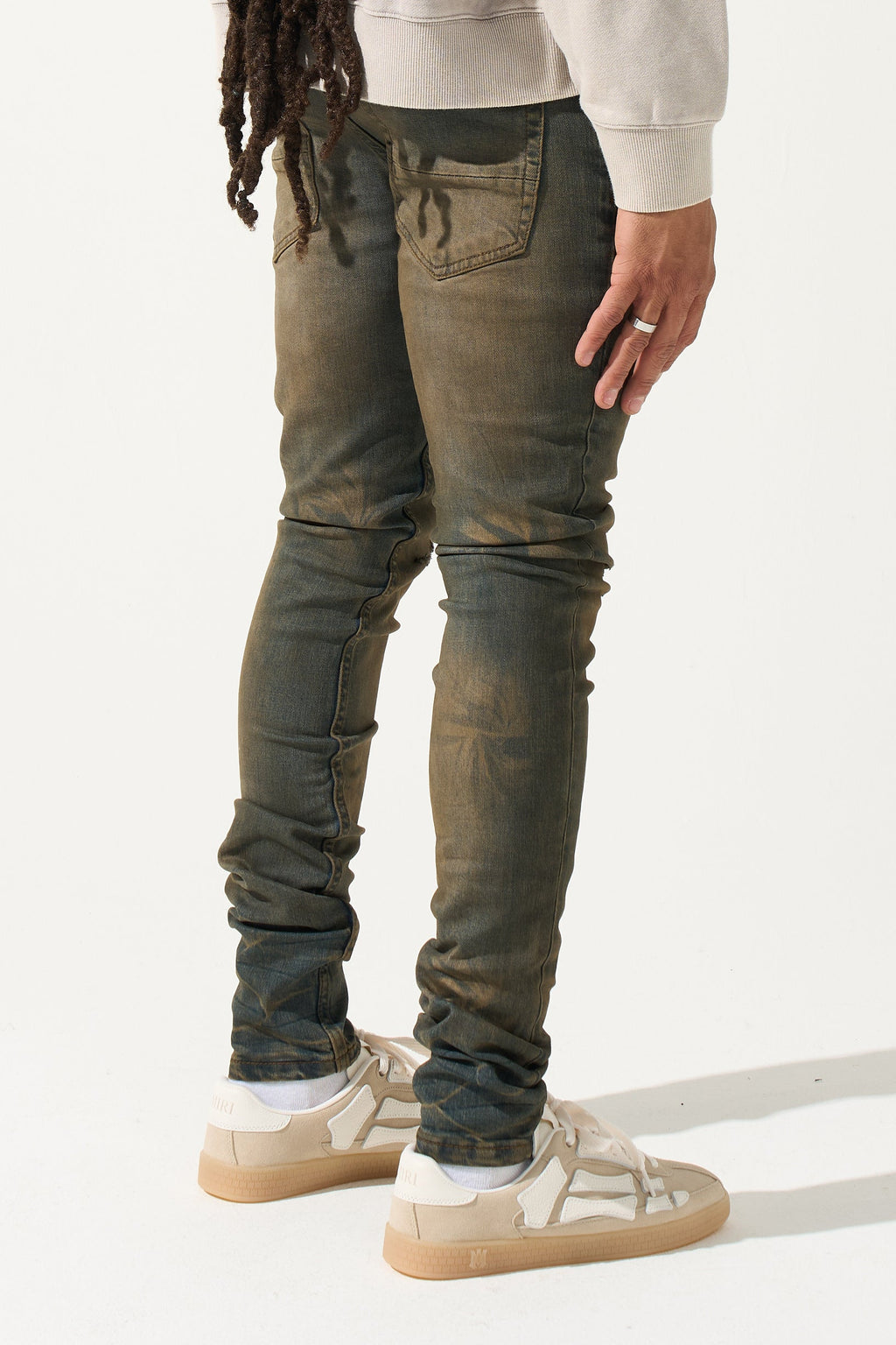 Earth-brown men's slim jeans with side view yoke stitching and ruched knees.