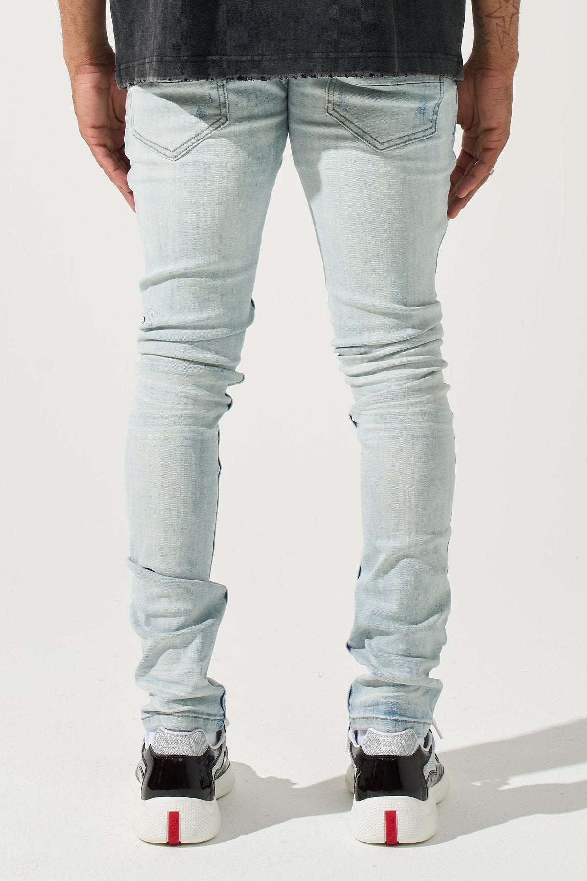 Light blue men’s jeans showing back pockets and worn, creased wash finish