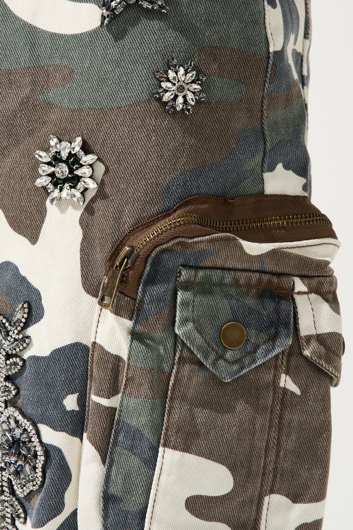 Men's camo cargo shorts close-up with floral embellishments and zip side pocket