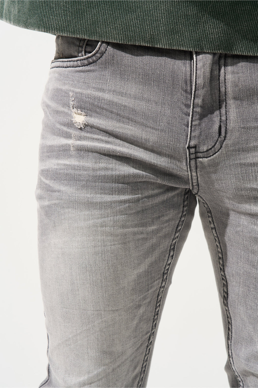 Grey men’s jeans close-up: front fly, faded wash, and stitched seams