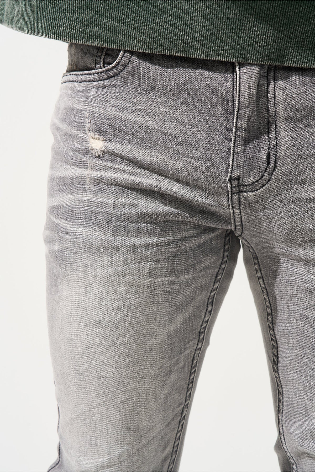 Grey men’s jeans close-up: front fly, faded wash, and stitched seams