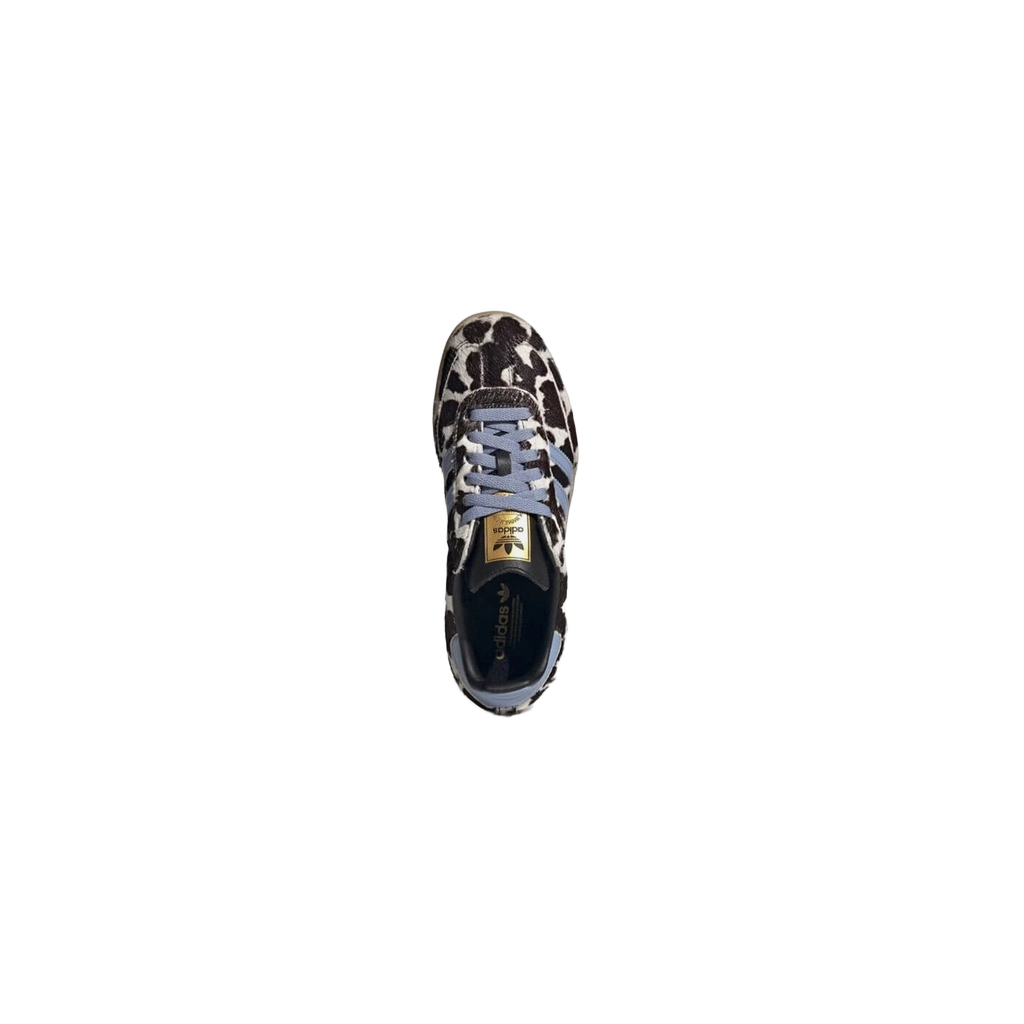 Cow-print low-top sneaker front view, gray laces, light blue stripes, gum sole