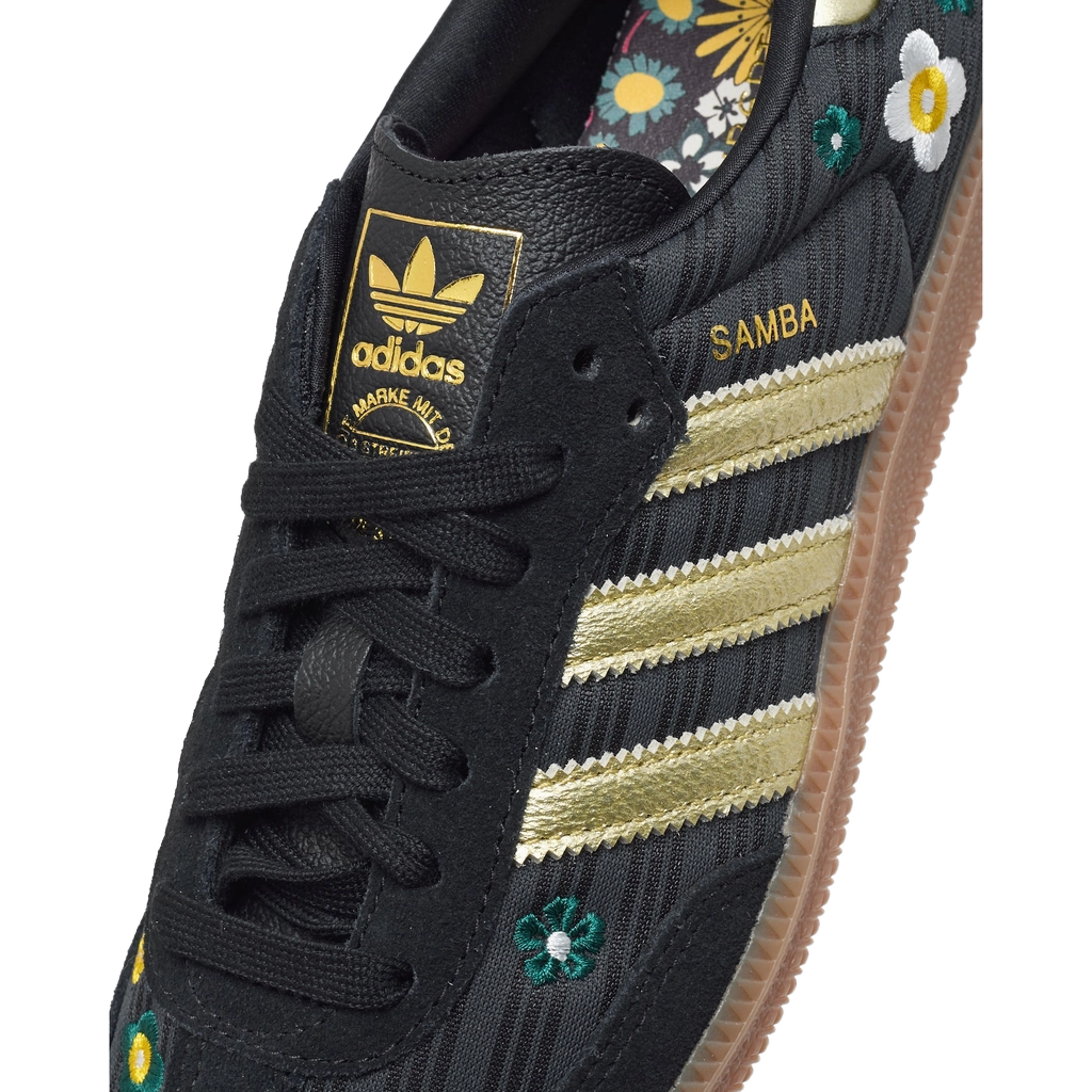 Adidas Samba OG shoe upper closeup, black leather with gold stripes and adidas label